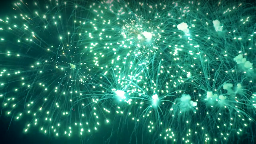Green fireworks explode against the backdrop of a dark night sky