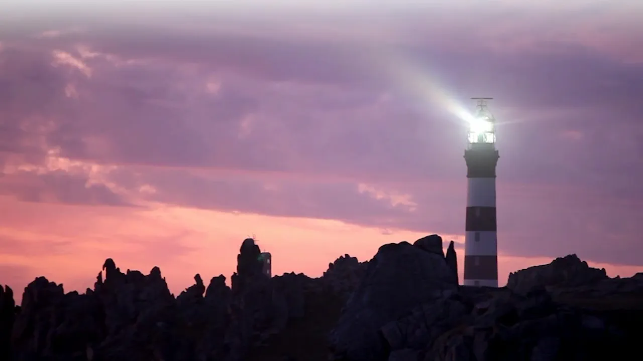 A lighthouse beams light across a rocky coastline at dusk, symbolizing Hogan Lovells as a beacon of innovation and guidance in a changing world.